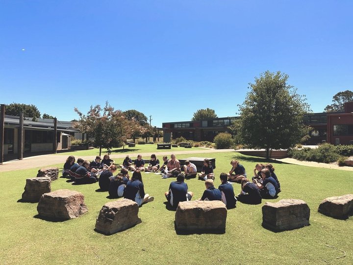 Students sitting in a circle on the lawn at Daylesford Secondary College