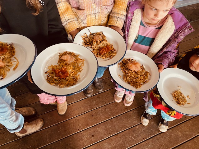 Students holding plates of hot food at a school breakfast